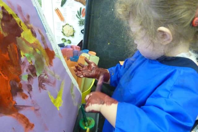 Exploring the rather messy art of finger painting at Catkins Nursery!