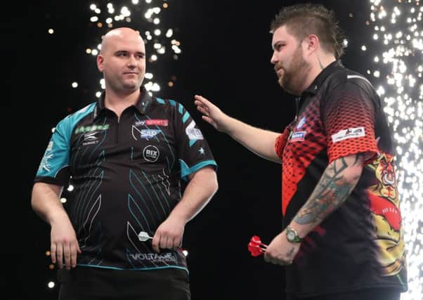 Rob Cross is congratulated by Michael Smith at the end of the match. Picture courtesy Lawrence Lustig/PDC