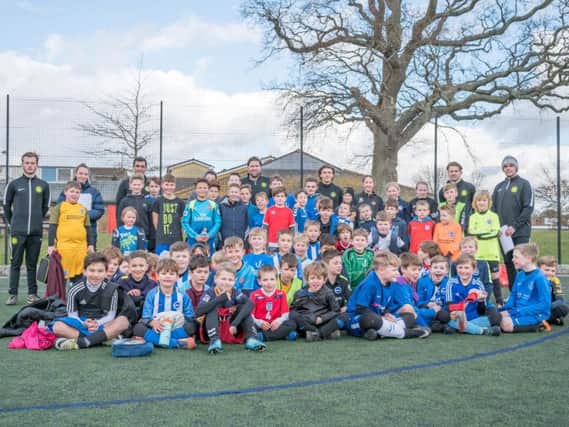 Adam Virgo pictured with his coaches and a group of children at his academy.