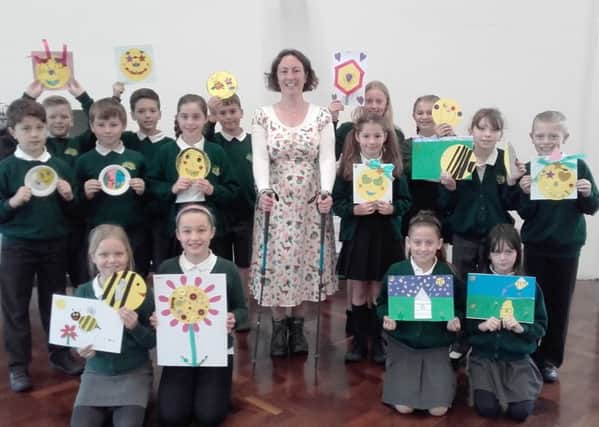 Head teacher Rebecca Jackson with pupils showing the emojis they made after a visit to St Barnabas House