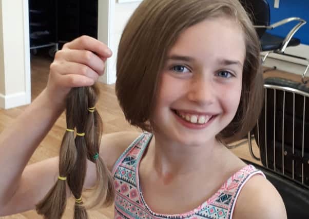 Cerys holding her donated ponytails