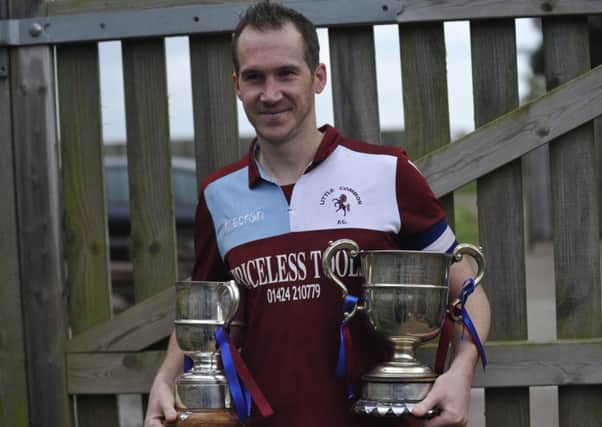 Little Common Football Club captain Lewis Hole clutches the Macron Store Southern Combination League Division One trophy and Division One Challenge Cup.