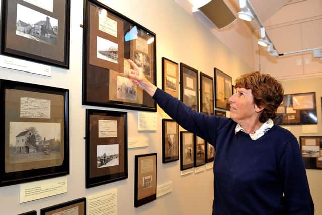 Volunteer Carol Pople checks out some of the Shoreham photographs in The Camera as Recorder, an exhibition at Marlipins Museum. Picture: Steve Robard SR1812140