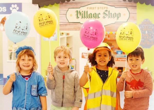 Children holding balloons at first steps village launch
