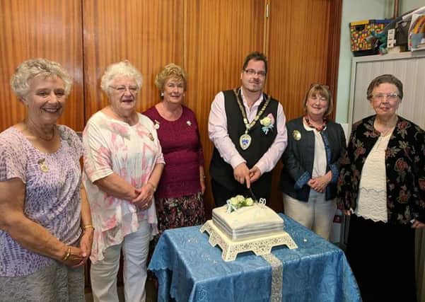 Billy cutting the cake at Littlehampton and District Flower Club's diamond anniversary tea