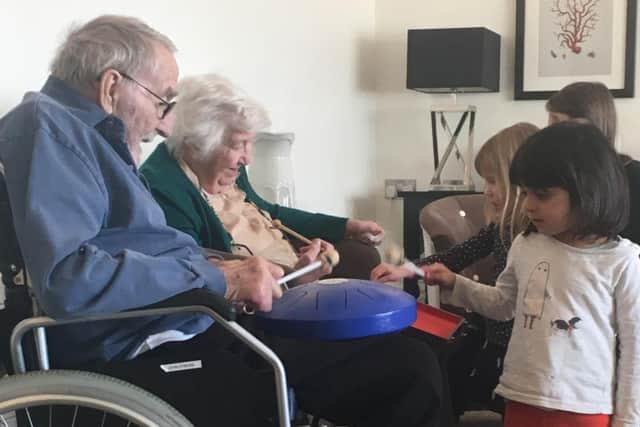 John, 78 andGretchen, 92, playing instruments with the children