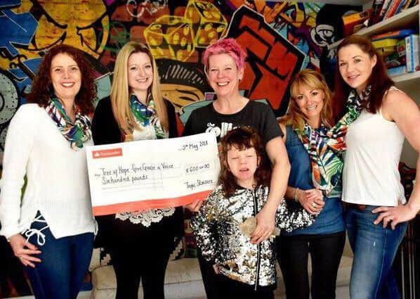 Tropic Skincare presenting the cheque. Picture: Kate Henwood Photography