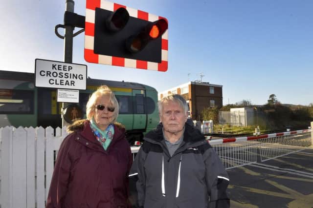 Gillian Clare and Peter Cox at Polegate Railway crossing where Gillian's mother was struck on the head by one of the barriers (Photo by Jon Rigby) SUS-180118-094947008