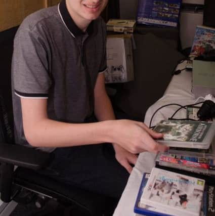 Alex Mahoney tests games and consoles donated to the hospice shops