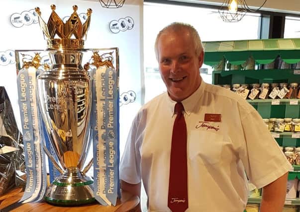 Jempson's Rye store manager Neil Sheppard alongside the Premier League trophy.
