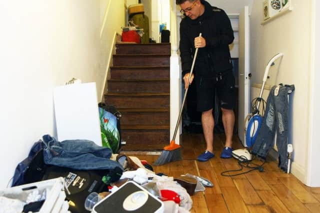 Wayne McConnell cleaning his flat in South Terrace, Littlehampton, the day after the flooding. Picture: Derek Martin