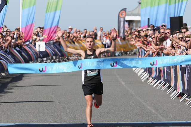 James Westlake breaks the tape in the 2018 Worthing 10k. Picture by Eddie Mitchell