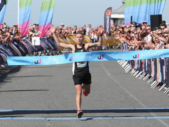 James Westlake breaks the tape in the 2018 Worthing 10k. Picture by Eddie Mitchell