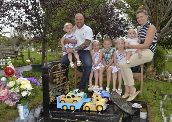 Aaron and Laura Ripley with children, Vinnie, Evie, Elsa, Ellie and Eryn at the grave at the cemetery in Hailsham of their son Henry (Photo by Jon Rigby)