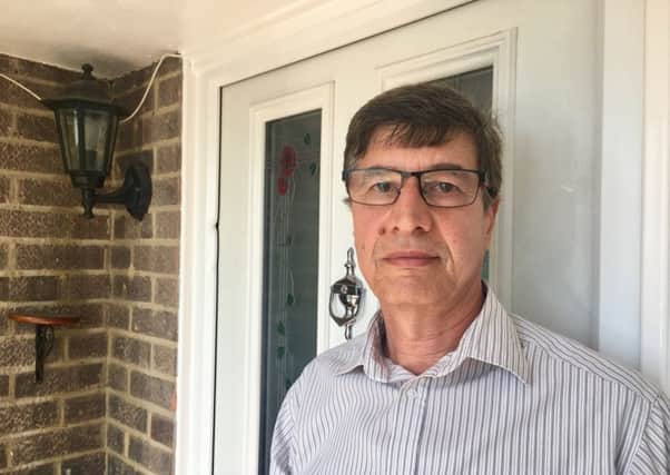 Mohamed Barakat, 63, from Goring, next to his front door which was broken into. The dent can be seen on the doorframe where the burglars forced one of the three locks.