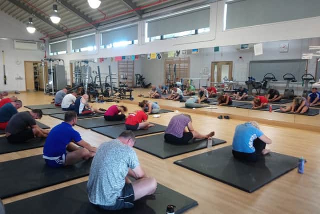 Current charity beneficiaries in a yoga session at The Fire Fighters Charity rehabilitation centre in Littlehampton