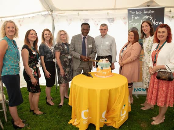 Patron Ambrose Harcourt cutting the birthday cake at the party for Chestnut Tree House