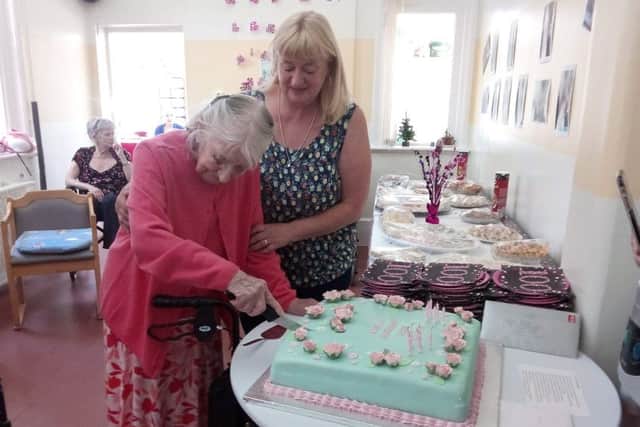 Eileen cuts her cake with the help of daughter Maggie