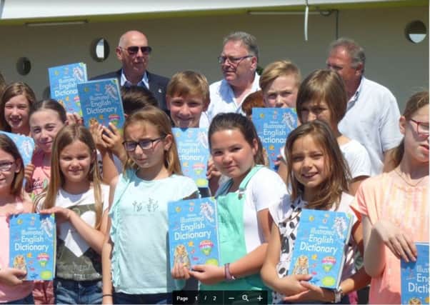 Rotarian Terry Herbert and mayor Gerard Delahaye with the children and their new Rotary dictionaries