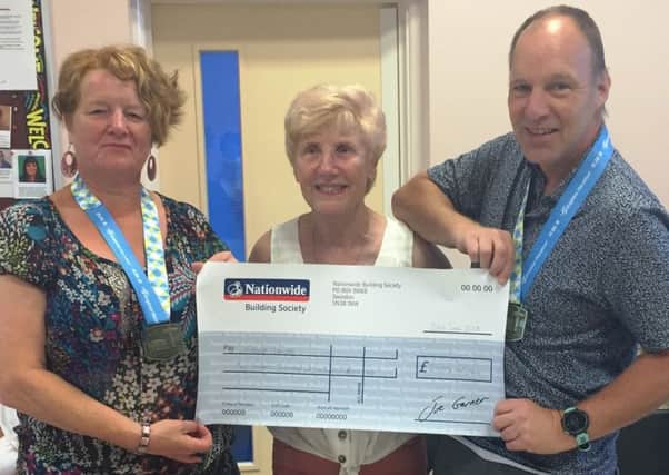 Gill and Richard Taylor present a cheque for Â£2,725.40 to Cancer United founder Jan Sheward, centre