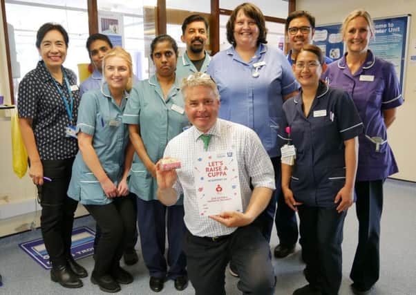 East Worthing and Shoreham MP Tim Loughton holding up the Big7Tea poster with staff on Broadwater Ward at Worthing Hospital