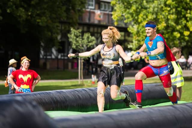 Kapow! Superheroes taking on the inflatable obstacle course for Martlets Hospice in Hove (Photograph: Neil Stoddart) SUS-180407-144223001