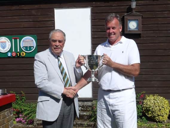 Singles champion Ray Bamford is presented his trophy by Quiller Barrett