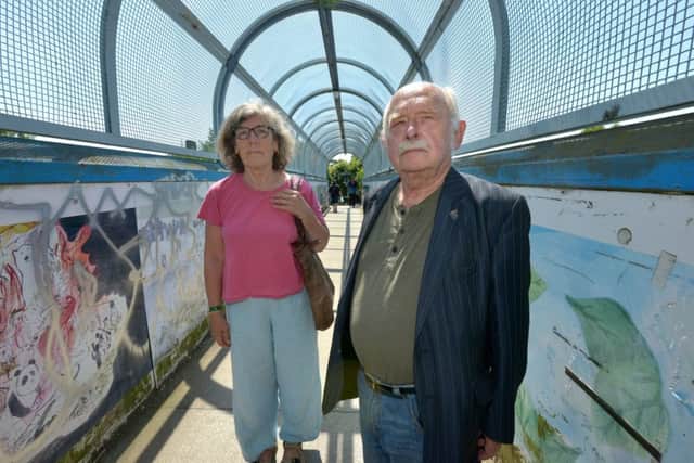 Lights and gates ... Cllr Annabella Ashby and Cllr Stephen Catlin at the footbridge over the railway line
