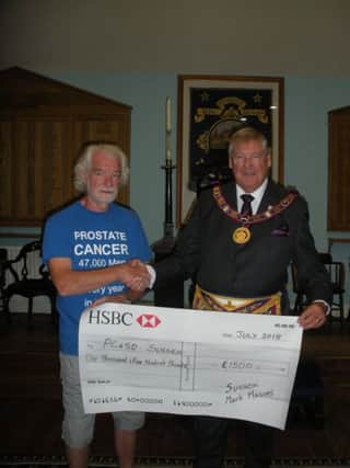 Martin Wilson, provincial grand master of Sussex Mark Masonry, presents a cheque to Roger Bacon, chair of the Prostate Cancer Support Organisation
