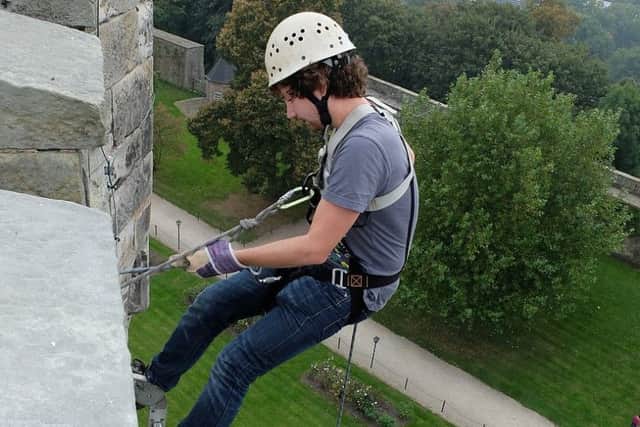A man at the beginning of his abseil down Arundel Castle