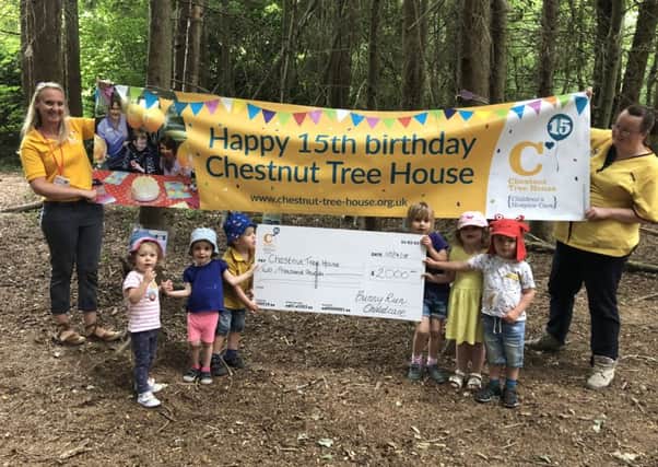 Children from Bunny Run childcare present cheque Chestnut Tree House SUS-180724-150834001