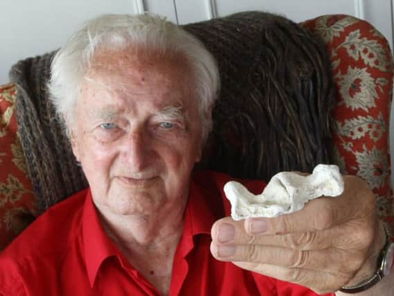 Leslie Firman, 90, with the bone he discovered on Worthing beach. Picture: Derek Martin