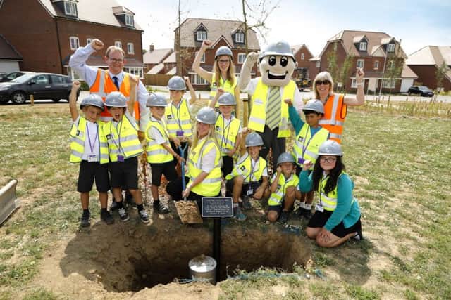 The pupils with the time capsule being buried at Bishop Park SUS-180725-114836001