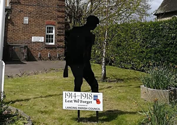 A silent solider silhoette stands in the grounds of Lancing Parish Hall to mark the centenary