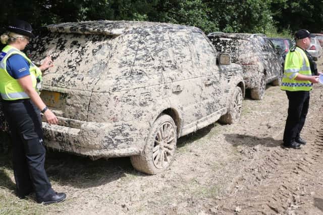 A muddy car left in one of the fields