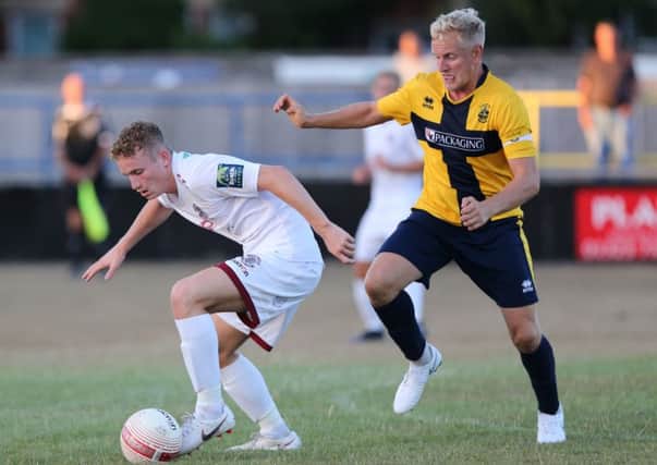 Adam Lovatt tries to turn away from former Hastings United midfielder Simon Johnson during the friendly at Eastbourne Town on Tuesday night. Picture courtesy Scott White