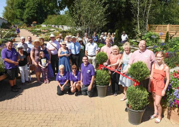 Caroline Notcutt cuts the ribbon to officially open the new display garden at Notcutts Garden Pride in Ditchling, with the Notcutts team and local dignitaries. (Credit: Vervate, Notcutts Garden Centres Ltd)