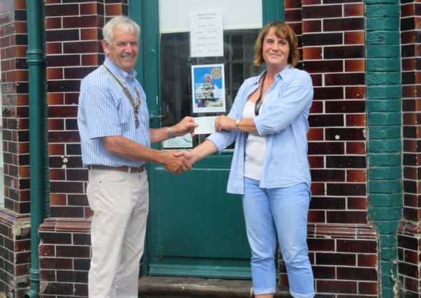 Bognor Hotham Rotary president Terry Farndell, presenting the first Â£100 cheque to Mandy who helps to manage the food bank store in Bognor Regis
