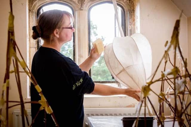 Volunteer Melanie Hodge creating new lanterns in the mansion attic at Wakehurst