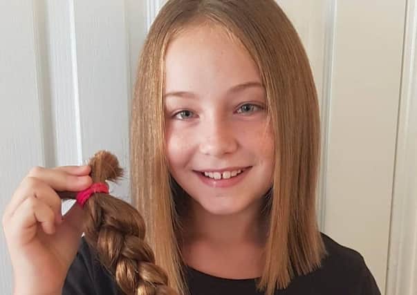 Lydia Conway proudly holds up the hair she donated to Little Princess Trust