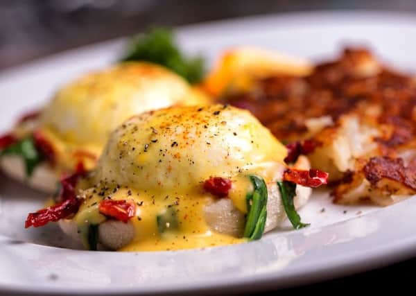 Fancy eggs benedict with sun dried tomatoes and spinach, coffee and orange juice