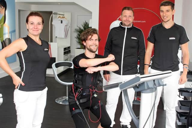 DM1881781a.jpg Worthing Herald reporter James Butler tries out Bodystreet in Worthing ahead of its opening, - a gym where you put on a bodysuit which gives your muscles electric shocks while you're working out. With staff (from left) Diana Stegaru, James Holland and Charlie Mathe. Photo by Derek Martin Photography. SUS-180817-203007008