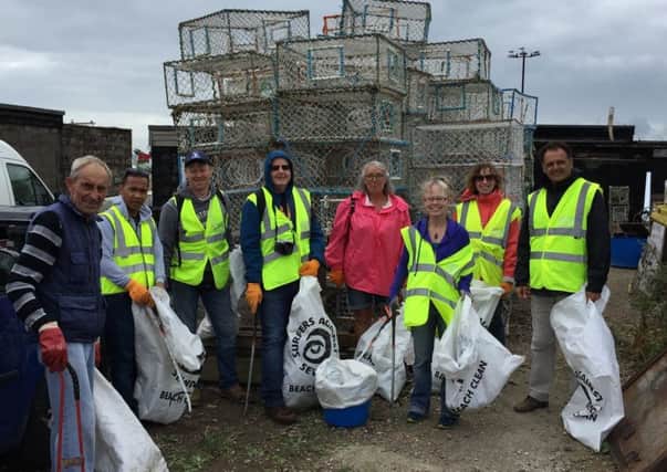 Volunteers help to clean up the fishing beach at Rock a Nore, Hastings SUS-180829-120230001