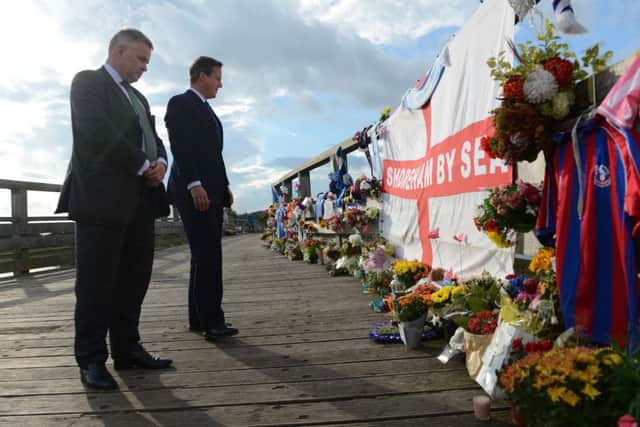 David Cameron met with Tim Loughton, MP, to lay flowers to commemorate the eleven people who lost their lives when a vintage Hawker Jet crashed onto the busy A27 in West Sussex. The aircraft was part of a display at Shoreham Airshow on 22nd August 2015. After laying flowers the Prime Minister attended a reception at Brighton and Hove Football Club training ground to meet emergency service representatives, volunteers and local MPs. The old Shoreham Toll Bridge has become a memorial for those wishing to pay respects to those who lost their lives that day. SUS-150918-215713001