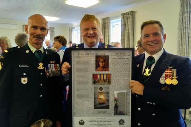 Town mayor councillor James Knight receives a wall hanging depicting Sgt Knight form Chief Warrant Officer Kent Griffiths, CD and Lieutenant Colonel (retired) Lee Villiger, CD