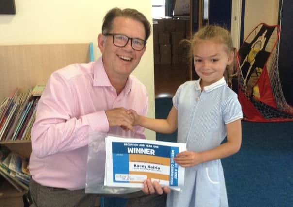 Kacey Keirle from River Beach Primary School receives her prize from Chris Seaton, chief executive of Schoolsworks