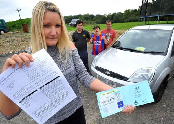 Oak Tree Farm day care center for adults are fighting a parking ticket given to them at Steyning leisure centre. It was issued after staff forgot to put a blue badge on their car after dealing with a seizure and another one of the adults running away. Denise King (from OTFDCC) holding the blue badge and Parking fine. Pic Steve Robards SR1823394 SUS-180409-152214001