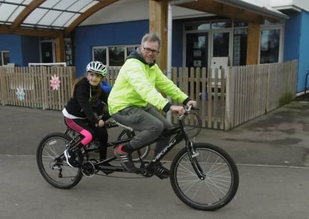 Rob using a tandem to help teach pedalling techniques to a River Beach Primary pupil