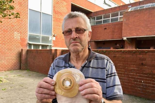 John McCartney, 70, from Boundary Road, Lancing, holding one of his catheter bags and flanges outside the place that he parked in Chatsworth Road, Worthing, behind the wall