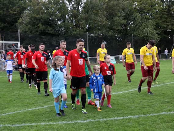 Mascots Gabs Storey and Rebecca Sullivan wirh 6 year old Joel Hudson  lead the teams out. Picture by Ron Hill